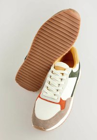 Baskets multicolores avec une tige en mesh et des accents en daim. La palette de couleurs comprend du blanc, de l'orange, du vert et du beige. Semelle en caoutchouc texturé.