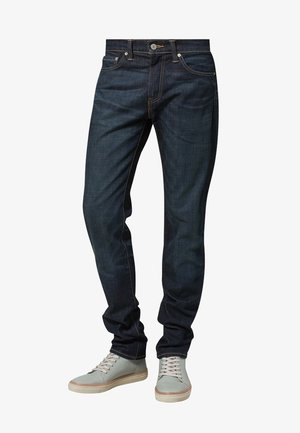 Dark blue denim jeans with a straight cut, featuring contrast stitching and five-pocket design. Paired with light blue sneakers.