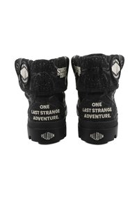 Mustad kõrge säärega tossud, millel on tekstureeritud materjal. Tagaküljel on valge trükitud tekst, külgedel ümmargused logod ning vastupidav kummist tald.