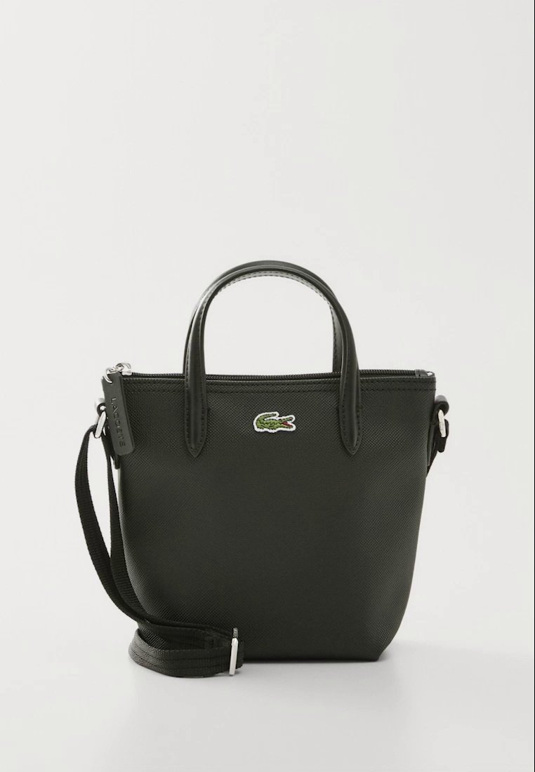 Petit sac à main en cuir noir avec deux poignées, bandoulière amovible, fermeture éclair et logo crocodile vert sur le devant.