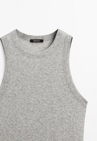 Lichtgrijs mouwloos topje met een ronde hals, textuur van geribbeld materiaal en een klein zwart label met "Massimo Dutti" op de halslijn.