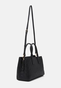 Czarna pikowana torebka ze skóry z dwoma górnymi uchwytami i odpinanym paskiem na ramię. Posiada kieszeń na zamek oraz złote elementy ozdobne.