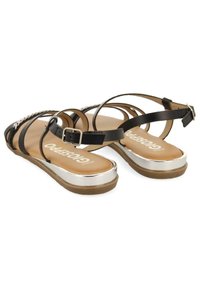Černé syntetické sandály s více pásky, stříbrnými detaily na podrážce a hnědým vnitřkem s logem. Nastavitelné spony kolem kotníku.