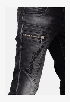 Jean en denim noir avec une coupe ajustée, poche zippée, logo brodé et une finition délavée et texturée le long des jambes.