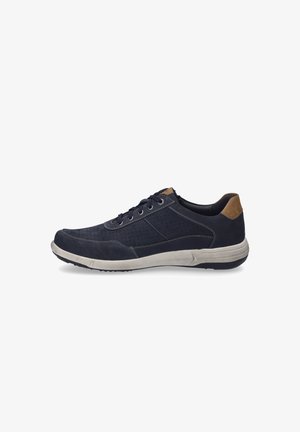Zapatilla deportiva azul marino con diseño perforado, talón beige en contraste y suela color beige. Cuenta con cierre de cordones y parte superior texturizada.