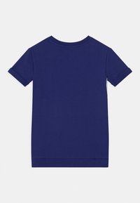 Ein einfarbig dunkelblaues Kurzarm-T-Shirt mit umgekrempelten Ärmeln, flach ausgelegt und mit der Rückseite auf einem weißen Hintergrund.