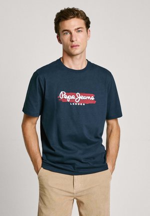 Camiseta de algodón azul marino con un logo blanco y rojo "Pepe Jeans LONDON" en el pecho. Ajuste estándar con cuello redondo.