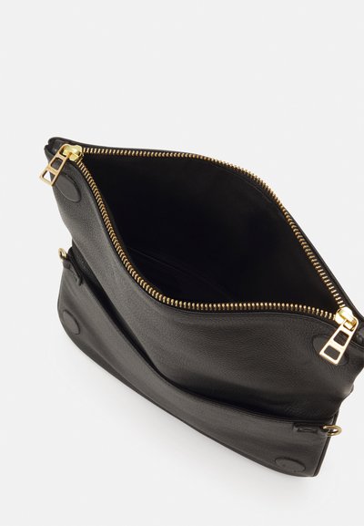 Borsa nera in pelle con superficie testurizzata, chiusura a zip dorata e tasca interna. Presenta bordi inclinati e sottili dettagli in metallo.
