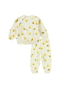 Set di pigiama a due pezzi in morbido tessuto giallo con vari stampati di emoji. La parte superiore presenta maniche raglan; i pantaloni hanno una vita elastica.