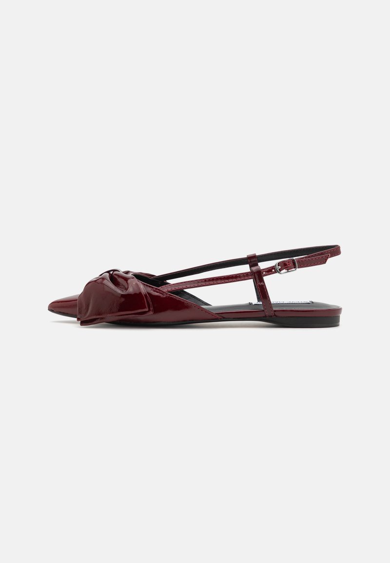 Ballerine slingback in pelle patinata borgogna con punta appuntita e dettaglio a nodo sul ponticello. Presentano una cinghia alla caviglia regolabile e suola piatta.