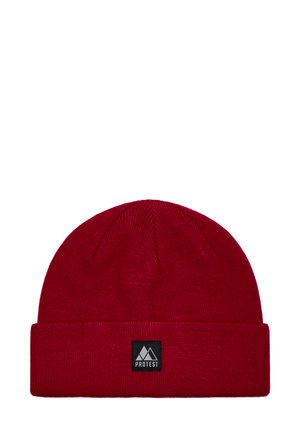 Red knitted beanie with a folded cuff, featuring a rectangular black label with a mountain logo and the word "PROTEST." Smooth texture.