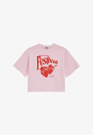 T-shirt rose clair raccourci avec texte rouge "Strawberry Festival" et deux grandes fraises graphiques centrées sur le devant.