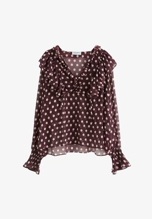 Burgundy blus med prickar och volanger på axlar och halsringning. Lättviktig genomskinlig tyg, långa ärmar med elastiska manschetter.