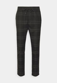 Zwarte geblokte broek met een elastische tailleband, trekkoordsluiting en een zachte textuur. Rechte pijpen met contrasterende lichte lijnen.
