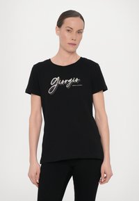 Juodas medvilninis marškinėliai su trumpomis rankovėmis ir apvaliu kaklu. Priekyje yra metalinis "Giorgio" grafiką ir tekstą "Armani Exchange".