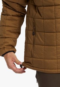 Brown insulated jacket with a quilted pattern. Features a zippered pocket and adjustable drawstring at the hem. Soft texture, warm material.