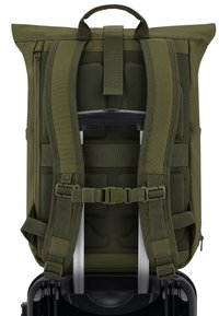 Zelený batoh s polstrovaným síťovým zadním panelem, nastavitelnými popruhy a horním držadlem. Obsahuje zesílené upevnění pro rukojeť kufru níže.