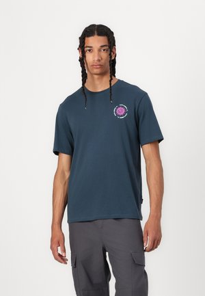 Navy blue cotton t-shirt with short sleeves and a crew neckline. Features a round purple graphic design on the chest.