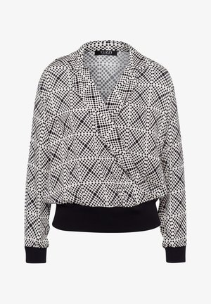 Zwart-witte blouse met polkadots en een wikkelontwerp, lange mouwen en een zwarte geribbelde zoom. Lichtgewicht stof met een gladde textuur.