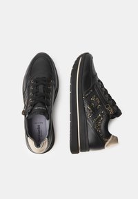 Schwarze Ledersneaker mit strukturierten Akzenten, goldenen Beschlägen und einem seitlichen Reißverschluss. Ausgestattet mit einer Memory-Schaum-Einlegesohle und einer kontrastierenden Gummisohle.