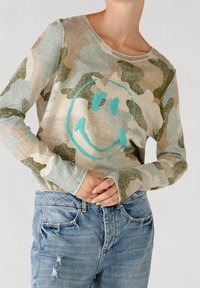 Maglione a maniche lunghe in camouflage nei toni del beige chiaro, blu e verde con un sorriso ricamato color turchese sul davanti.