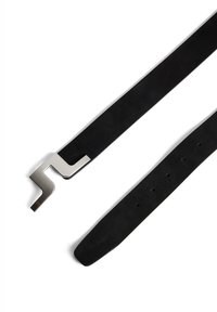 Svart mockaskärp med en elegant, metallspänne format som ett "L". Har flera hål för justering. Slät textur och minimalistisk design.