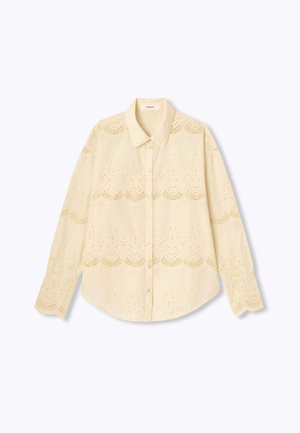 Chemise à manches longues jaune clair avec une fermeture à boutons, présentant des motifs brodés en œillets et un design de col classique.