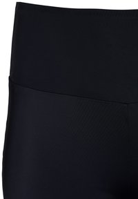 Crne tajice visokog struka izrađene od glatkoga, rastezljivog materijala; imaju široku traku u struku i minimalne šavove za elegantan izgled.