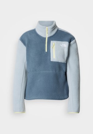 Fleecepullover in zweifarbigem Blau, mit Viertel-Reißverschluss, hohem Kragen, linksseitiger Brusttasche mit Reißverschluss und gelben Akzenten.