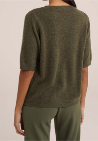 Olivgrön kortärmad tröja med rund hals, tillverkad av mjukt material, som har en texturerad yta och en avslappnad passform.