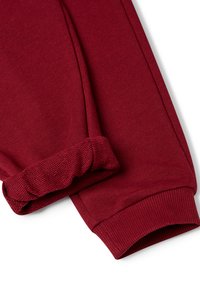 Bordeaux sweatpants hebben elastische boorden, een ribbeltextuur en een gladde stof, die strakke lijnen en een getailleerde vorm benadrukken.
