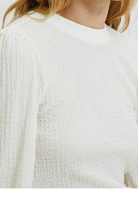 Maglione bianco in tessuto testurizzato con scollatura rotonda a costine, caratterizzato da un tessuto stropicciato e maniche lunghe. Nessun motivo o dettaglio visibile.
