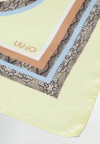 Firkantet tørklæde i blødt stof med en lys gul baggrund og lagdelte geometriske mønstre i brun, blå og slangeskindsaccent.
