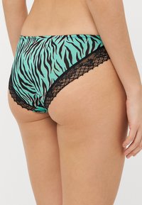 Aqua and black zebra print brief with lace accents along the edges, featuring a smooth texture and a high-cut design.