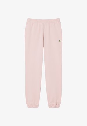 Pantalon de survêtement rose clair avec taille et poignets élastiques, arborant un petit logo crocodile vert sur la cuisse gauche haute.