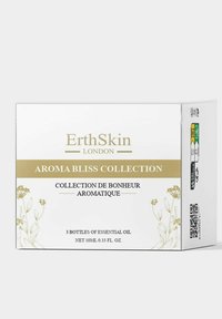 Zestaw Aromatyczna Rozkosz ErthSkin zawiera eleganckie złote napisy na białym tle, w środku znajdują się trzy butelki olejków eterycznych o pojemności 10 ml.