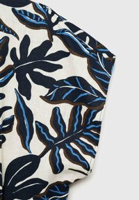 Tissu en coton présentant un motif de feuilles navy et crème avec des accents bleus. Le design comprend différentes formes et textures de feuilles.