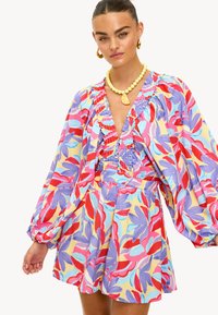 Robe multicolore avec motifs de feuilles pastel, col à volants, manches bouffantes, taille cintrée et jupe évasée.