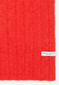 Tissu tricoté rouge vif avec une texture visible et une étiquette de marque Marc O'Polo blanche cousue dans le coin inférieur droit.