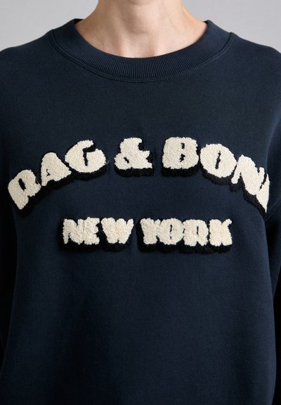 Granatowy sweatshirt z haftowanym napisem "RAG & BONE NEW YORK" w kremowych i czarnych, puszystych literach. Posiada okrągły dekolt i teksturowany materiał.