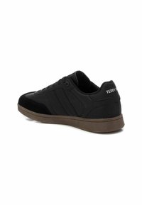 Sneaker sportive nere con una toma superiore in sintetico liscio, accenti in suede, design a tre strisce e suola in gomma marrone. Logo del brand sul tallone.