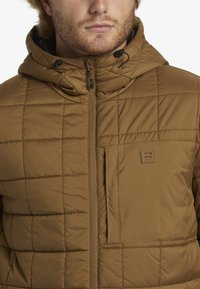Quilted puffer jacket in brown with a hood, featuring a zip closure and a chest pocket. Smooth texture with dark accents.