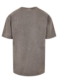 T-shirt grigio a maniche corte con scollatura rotonda. Realizzato in un tessuto testurizzato, presenta una finitura sbiadita e dettagli di cucitura visibili.