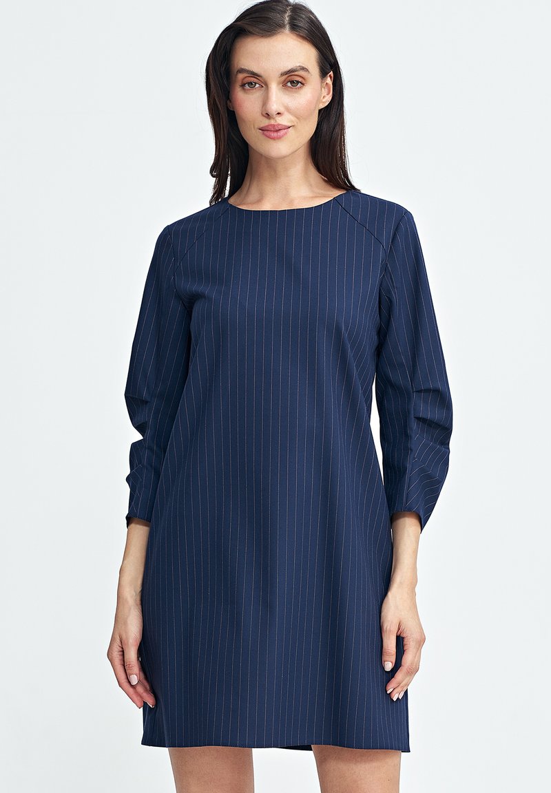 Granatowa sukienka z pionowymi prążkami, okrągłym dekoltem, rękawami o długości trzech kwart, o luźnym kroju, wykonana z gładkiego materiału.