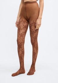 Καφέ καλσόν με λουλουδάτο δαντελωτό σχέδιο, κατασκευασμένο από διάφανο υλικό. Υψηλή μέση με ομαλή υφή, που καλύπτει από τη μέση μέχρι τα δάχτυλα των ποδιών.