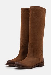 Ruskean mokkanahkaiset polvipituiset saappaat, joissa on stuckkuva kudottu pinta, pyöreä kärki ja matala pinottu korko vakauden takaamiseksi.