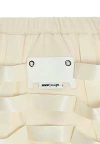 Organizador de tela beige con textura suave, con cintas de satén paralelas y una etiqueta rectangular blanca con dos ojales.