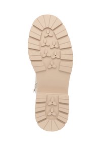 Suela de bota de goma beige con un patrón de relieve profundo, que presenta bordes redondeados y puntos de tracción elevados para una mejor adherencia.