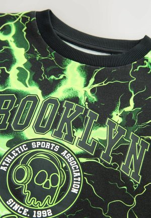 Sudadera negra con un brillante patrón de rayos verdes. Gráfico de "BROOKLYN" y calavera con auriculares impresa en negro y blanco en negrita.