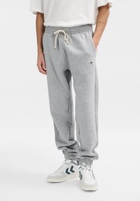 Graue Sweatpants aus weichem Baumwoll-Mix, mit elastischem Bund und Kordelzug sowie gerippten Bündchen. Kleines Logodetail an den Oberschenkeln.